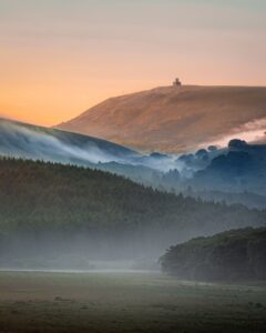 Sentinel Above the Mists — a solitary structure over a forest at dawn; award-winning fine art photograph by Mitsuki