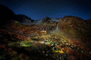 Valley of Lights — tents scattered across a mountain basin, a sky turned upside down; award-winning fine art photograph by Mitsuki