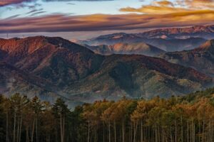 Layered autumn mountain ridgelines glowing under a dramatic sunset sky in central Japan, fine art landscape by Mitsuki